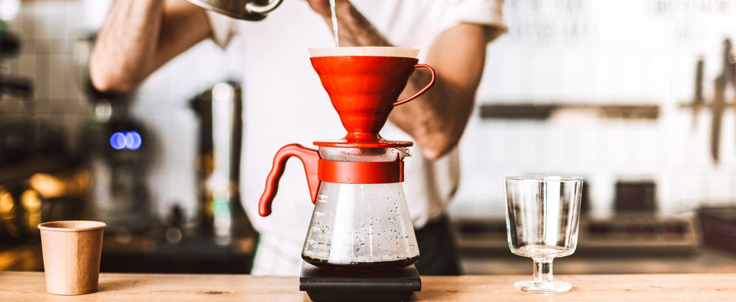Close up photo of barista standing at counter and preparing pour